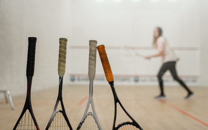 Squash rackets, female player on court on background. Girl on game training, active sport hobby on court, fitness workout for healthy lifestyle